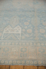 Distressed texture of a vintage Bijar runner, showing muted powder blue and beige geometric-floral patterns.