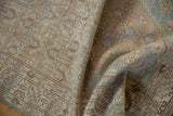 Folded vintage Distressed Borchalou rug showing soft texture and faded beige, dusty blue patterns.