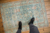Distressed Malayer rug with dusty blue, terracotta floral patterns and worn texture underfoot.