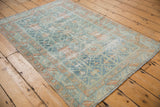 Vintage distressed Malayer rug corner, showing terracotta serrated leaf border and side selvage.