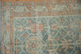 Vintage distressed Malayer rug close-up highlights dusty sky blue vinery field, terracotta florals, and mostly even wear.
