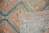 Vintage distressed Malayer rug runner's faded pattern and visible handwoven foundation.