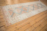 Distressed Malayer runner with repeating medallions and Herati border in sky blue, terracotta.