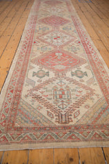 Low angle view of a vintage Serab runner showing its distressed pile and red geometric medallions.