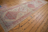 Long angled view of a distressed Serab runner showing its repeating column of geometric medallions.