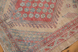 Detailed corner of a distressed Serab runner showing worn geometric patterns in red, blue, and beige.