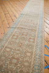 Distressed Hamadan runner with faded beige Herati motif and soft blue border.