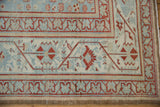 Corner of a distressed Malayer carpet highlighting the classic Serbend border and evenly worn pile.