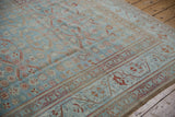 Angled view of the floral pinwheel pattern and even wear on a powder blue Malayer carpet.