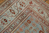 Geometric cherry red borders frame the powder blue field of a distressed Malayer carpet.