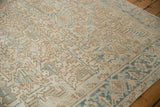 Distressed Mehrivan carpet field showcasing geometric layered plants and vinery in soft blue and beige.