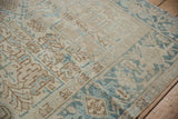 Distressed Mehrivan carpet close-up, light blue and pale coffee geometric vinery, worn texture.