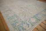 Distressed vintage Ahar carpet in soft ivory, sand, and pale denim blue floral patterns.