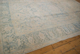 Pale blue curvilinear floral border and worn ivory field of vintage Ahar carpet.