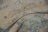 Distressed vintage Ahar rug pile with soft ivory and dusty blue curvilinear patterns.