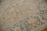 Faded ivory and dusty blue floral patterns on distressed Ahar rug, with faint foundation showing.