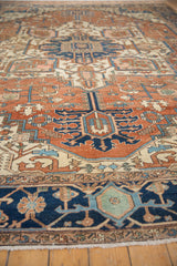 Antique Serapi rug's navy and terracotta geometric border with subtle cream details and fringe.