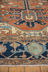 Intricate border detail of the antique Serapi rug, with terracotta, navy, ivory, and green geometric patterns.