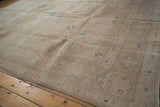 Faded sky blue palmettes and buds on the distressed sand field of a Sivas carpet.