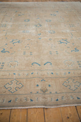 Corner detail of a vintage Distressed Sivas carpet, showing faded sky blue motifs and intact selvage.