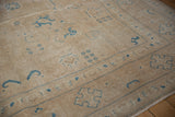 Distressed sand pile with faint foundation showing, sky blue border motifs.