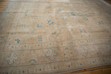 Distressed vintage Sivas carpet corner, sand field with sky blue geometric border patterns.