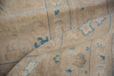 Rolled distressed Sivas carpet detail, sand and antique ivory pile, sky blue motifs.