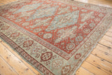 Antique Distressed Soumac rug corner: textured red field, seafoam green palmette, wave borders.
