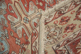 Close-up of folded antique Soumac rug, revealing flatweave back, patterned front, and distressed selvage.