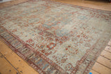 Distressed antique Soumac carpet revealing textured weave and softened sky blue, cherry red hues.