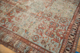 Distressed antique Soumac carpet section, showcasing worn sky blue, cherry red, and beige patterns.