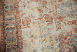 Geometric border and faded field motifs with exposed foundation on distressed Soumac carpet.