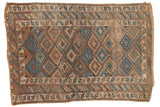 Antique Kurdish rug, geometric brown, indigo blue, green lattice pattern with visible wear.