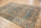 Antique Kurdish rug's geometric border, lattice pattern, and visible foundation wear.