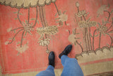 Partially asymmetric landscape pictorial motif of coral, ivory, and coffee blossoms on antique Khotan rug.