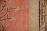 Antique Khotan border detail showing blush field with brown branch motifs and stylized bamboo pattern.