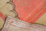Antique Khotan carpet detail showing blush pink and ivory pile with brown motif, woven back, and fringe.