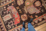 Stylized animals and trees on a pictorial vintage Khotan carpet in brown, peach, and mauve.