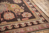 Khotan carpet border and field with chocolate brown, ivory, and peach stylized motifs.