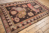 Corner view of a pictorial Khotan carpet border with ivory, peach, and brown patterns.