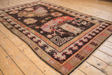 Fringed corner of vintage Khotan carpet showcasing pictorial brown field and geometric borders.