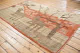 Terracotta border, deer motif, and fringed edge of a vintage Khotan carpet.