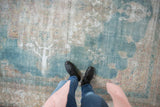 Distressed Khorassan carpet showing worn pile to foundation, with powder blue and ivory colors.