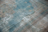 Distressed texture of vintage Khorassan carpet revealing faded powder blue and exposed foundation.