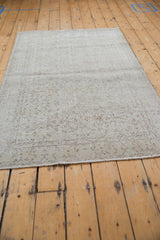 Distressed ivory and beige scrolling vinery pattern on a vintage Turkish Sparta rug.
