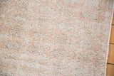 Close-up of the distressed rug's texture, showing a low pile and visible knot heads.