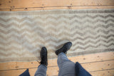 Distressed Tulu rug runner with textured ivory and beige chevron zig-zag pattern.
