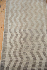 Distressed vintage Tulu rug's textured chevron zig-zag pattern in ivory and beige tones.
