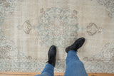Distressed vintage Sparta rug with worn ivory and dusty blue curvilinear design underfoot.