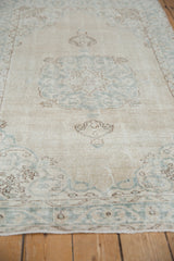 Distressed Sparta rug showing visible knot heads and faded blue vinery patterns.